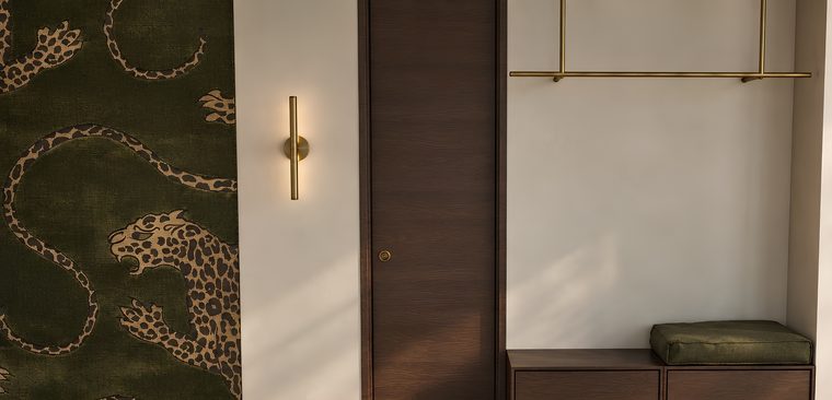 Předsíň s tapetou s levharty, mosazným světlem a lavicí